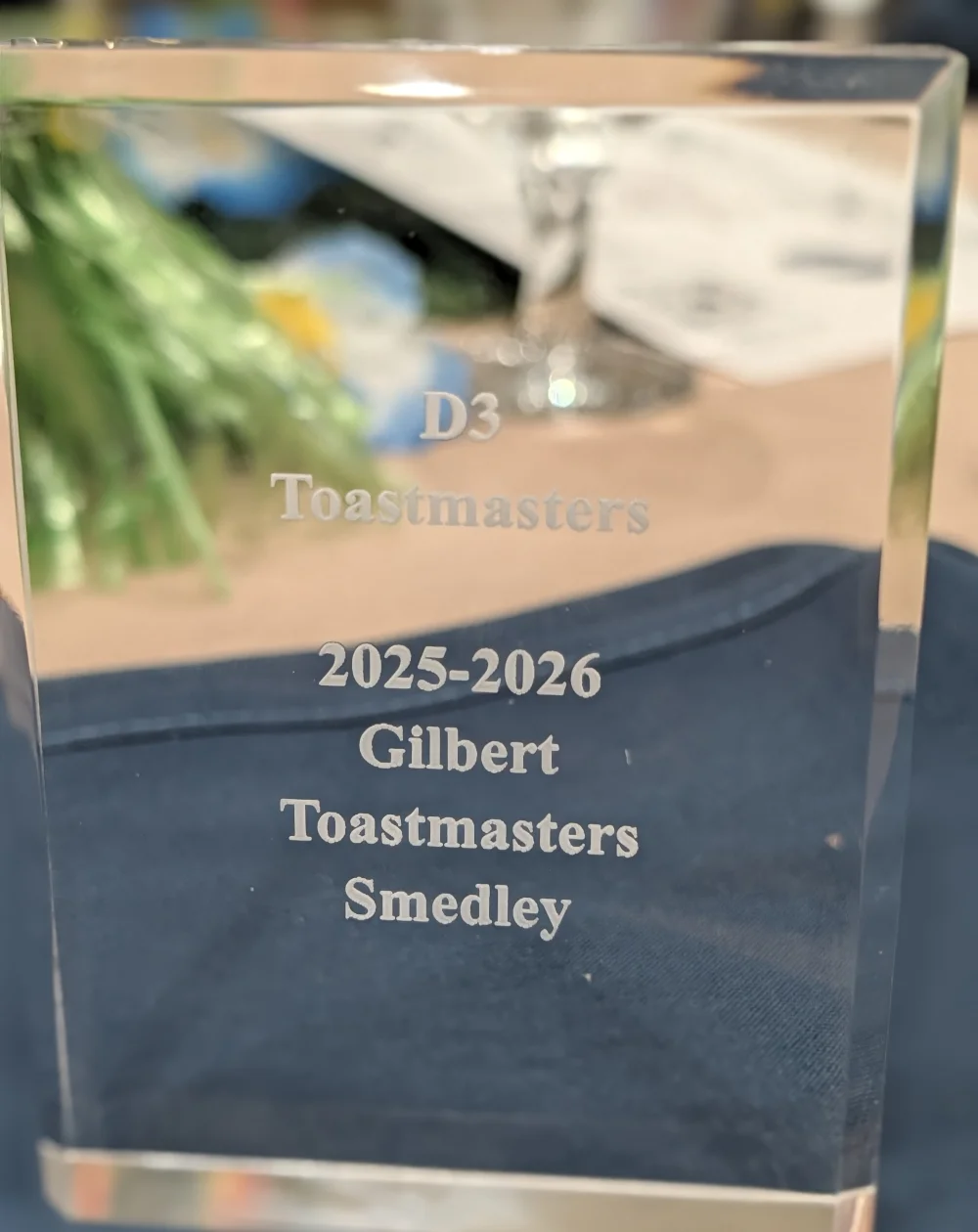 A clear acrylic award engraved D3 Toastmasters, 2025-2026 Gilbert Toastmasters Smedley